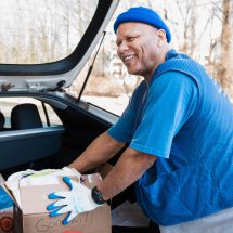 Sustainability 13 Man in a beanie unloading items from a car trunk