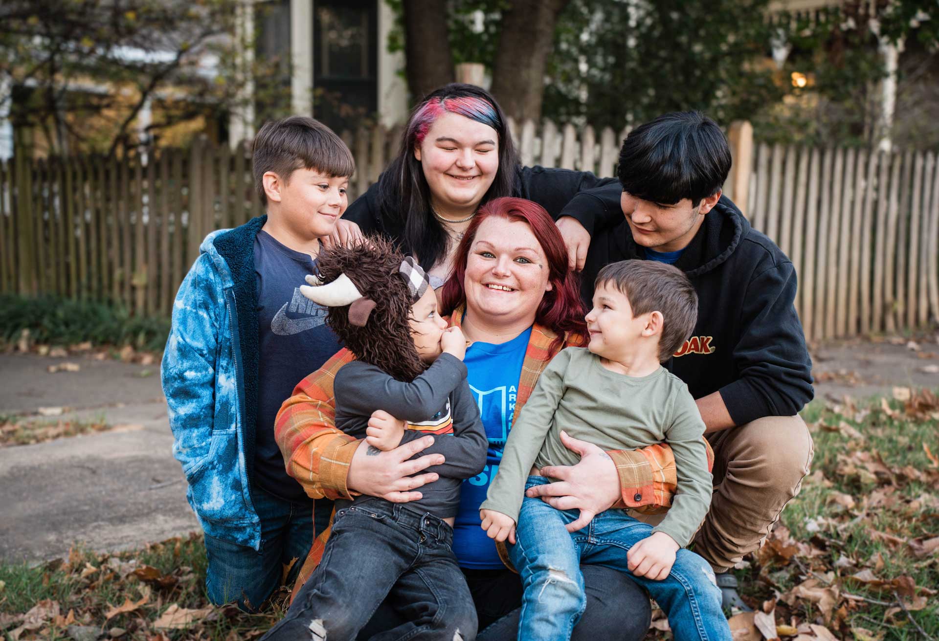 Look for the good 3 Smiling woman with her five kids happily surrounding her in front of their home